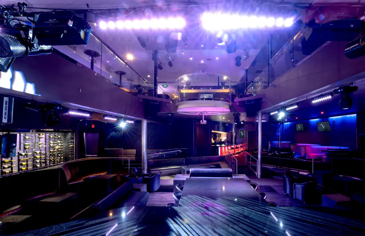 Venue 412 main dance floor with overhead lighting truss, theater lights, and the upper mezzanine railing visible above.