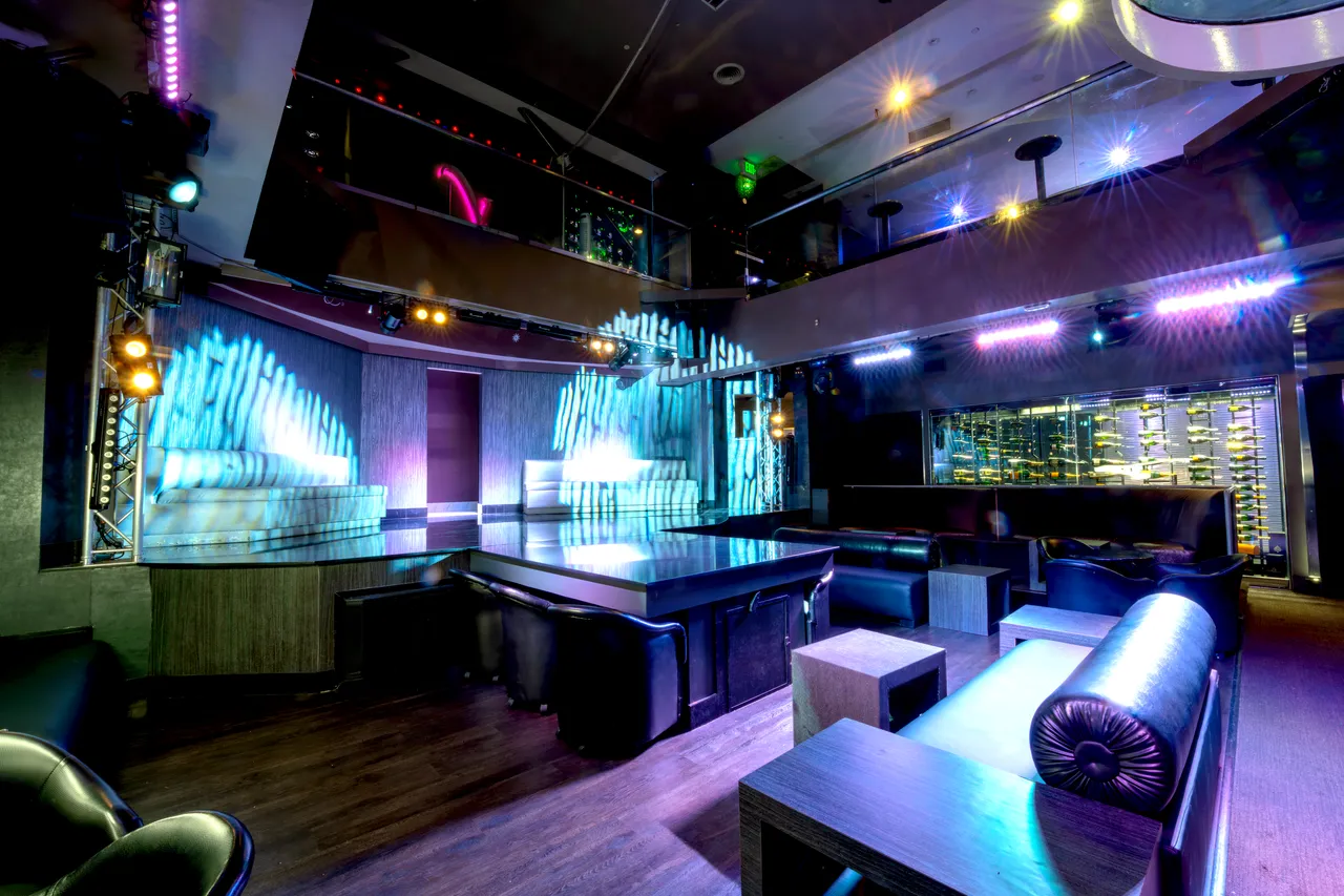 Venue 412 main floor showing the dual LED panel walls flanking the dance floor and the mezzanine wine display visible above on the right.